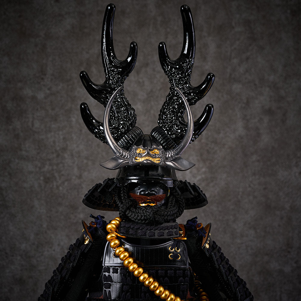 black samurai armor with dark blue string sitting on a black box