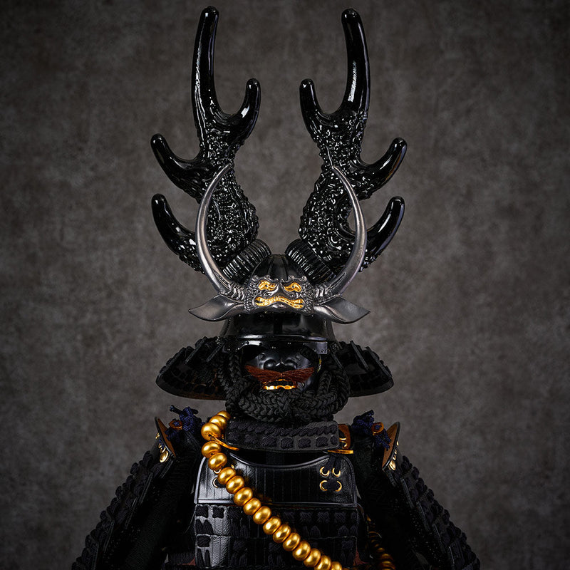 black samurai armor with dark blue string sitting on a black box